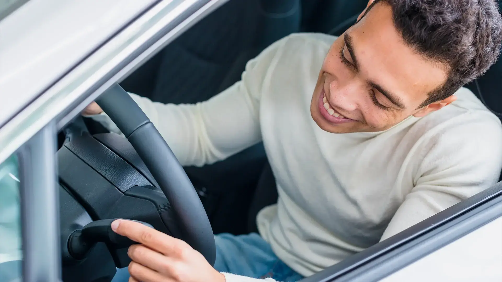 Homem feliz checando seu novo carro seminovo alugado