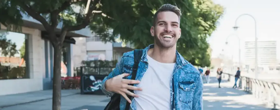 Jovem estudante sorrindo e usando uma mochila preta